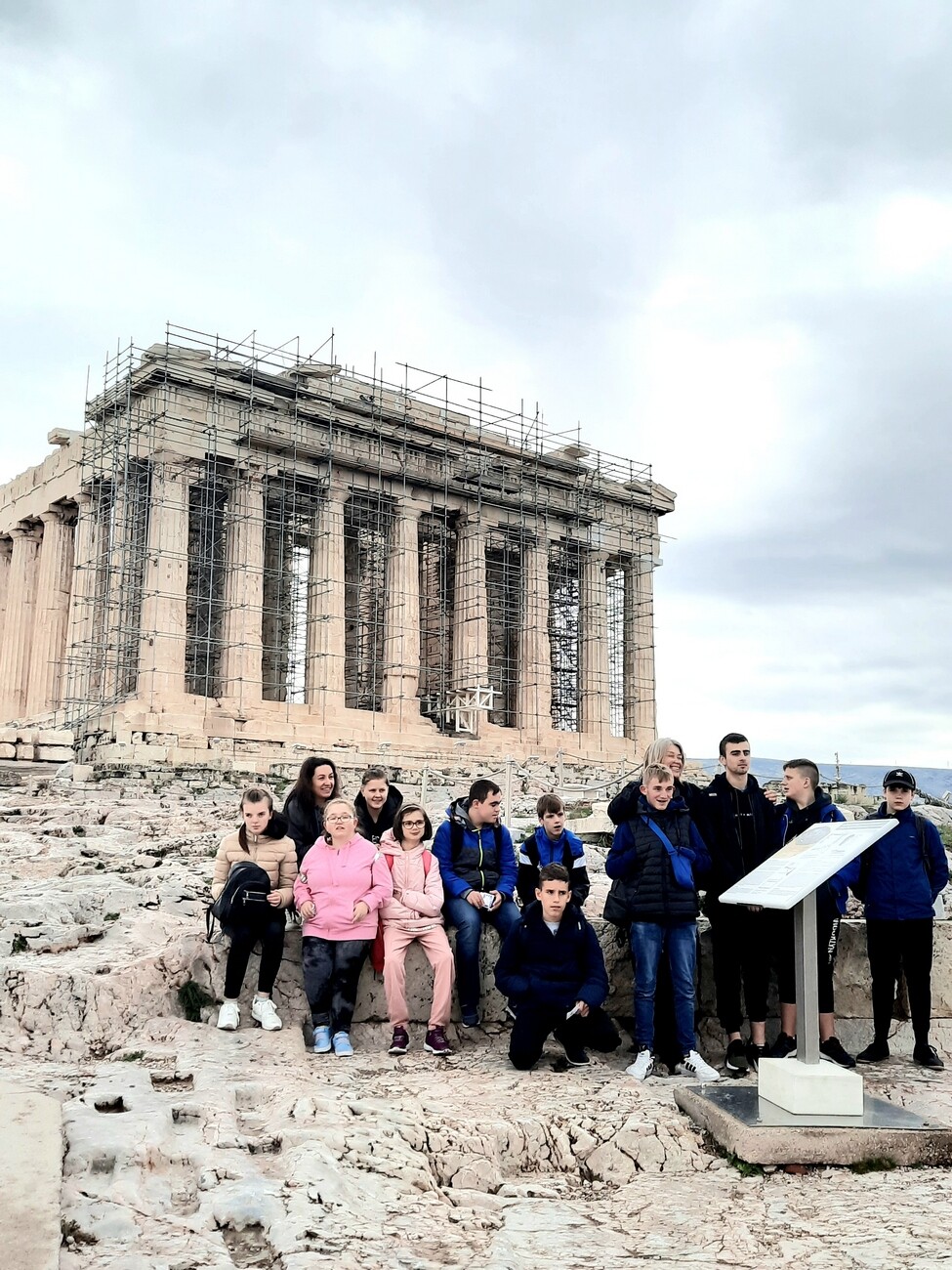 Grupa młodziezy pozuje do zdjęcia na tle Akropolu w Grecji