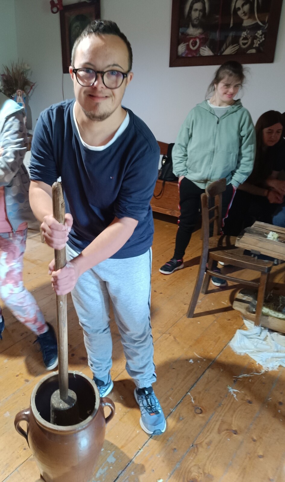 Chłopiec w okularach ubija masło w maselnicy.