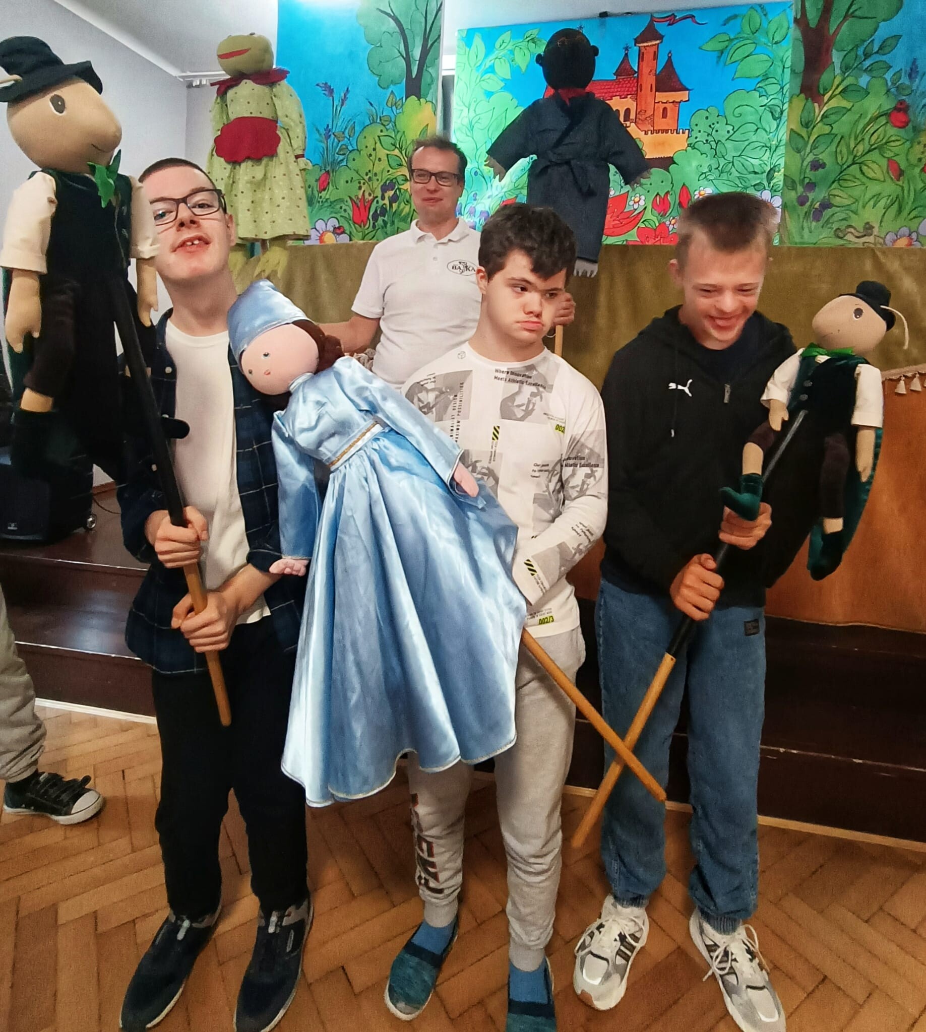 Uczniowie trzymają w dłoniach lalki teatralne.