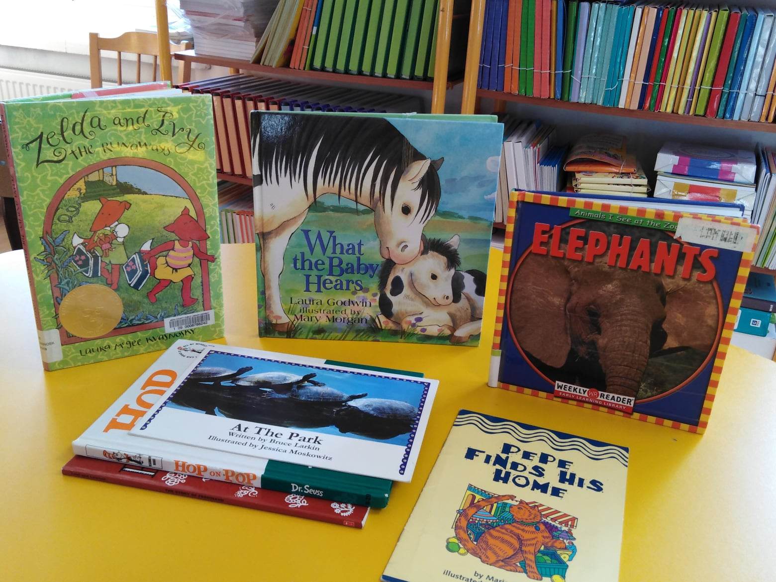 Książki dla dzieci w języku angielskim ułożone na stoliku w bibliotece szkolnej.