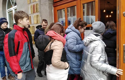 Grupa młodzieży wchodzi do budynku Biblioteki Publicznej w Bochni.