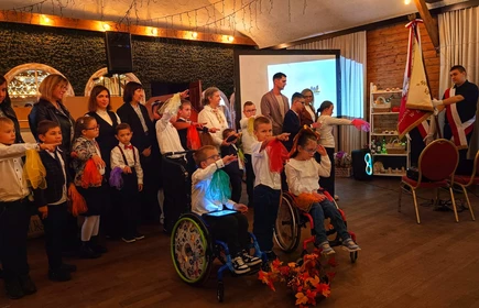 Uczniowie stoją z wyciagnietą prawą ręka skierowaną w strionę sztandaru szkoły, ślubują.