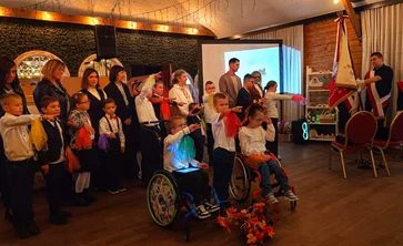 Uczniowie stoją z wyciagnietą prawą ręka skierowaną w strionę sztandaru szkoły, ślubują.