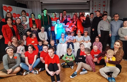 Uczniowie siedzą na schodach sceny  w sali teatralnej SOSW i pozują do zdjęcia.