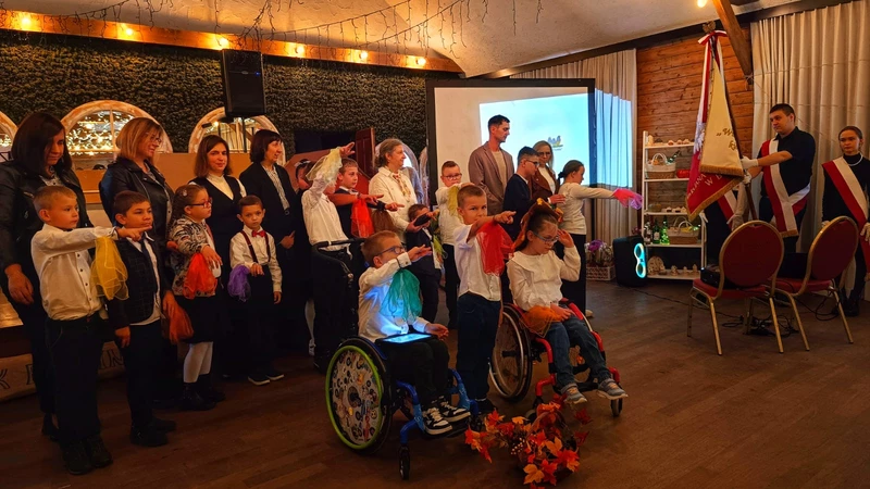 Uczniowie stoją z wyciagnietą prawą ręka skierowaną w strionę sztandaru szkoły, ślubują.