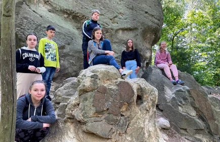 grupa młodzieży pozuje na tle skał