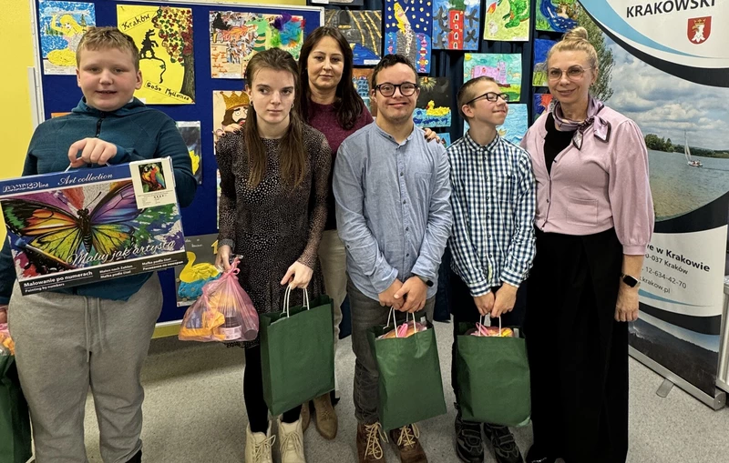 Czworo  nagrodzonych w konkursie uczniów pozuje do zdjęcia z nauczycielką.