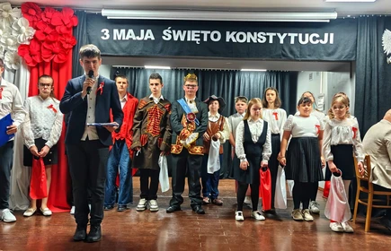 Uczniowie ubrani na galowo, wystepują na akademii z okazji rocznicy uchwalenia Konstytucji  3 maja.