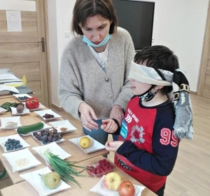 Dziewczynka rozpoznaje owoce po kształcie i fakturze