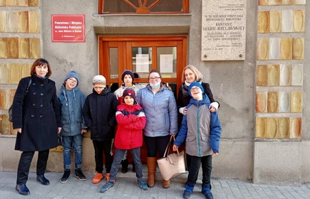 Grupa uczniów stoi przed wejściem do Publicznej Biblioteki w Bochni