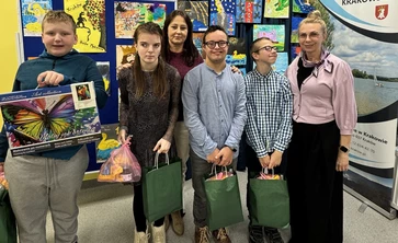 Czworo  nagrodzonych w konkursie uczniów pozuje do zdjęcia z nauczycielką.