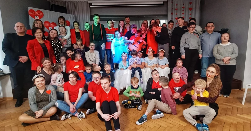 Uczniowie siedzą na schodach sceny  w sali teatralnej SOSW i pozują do zdjęcia.